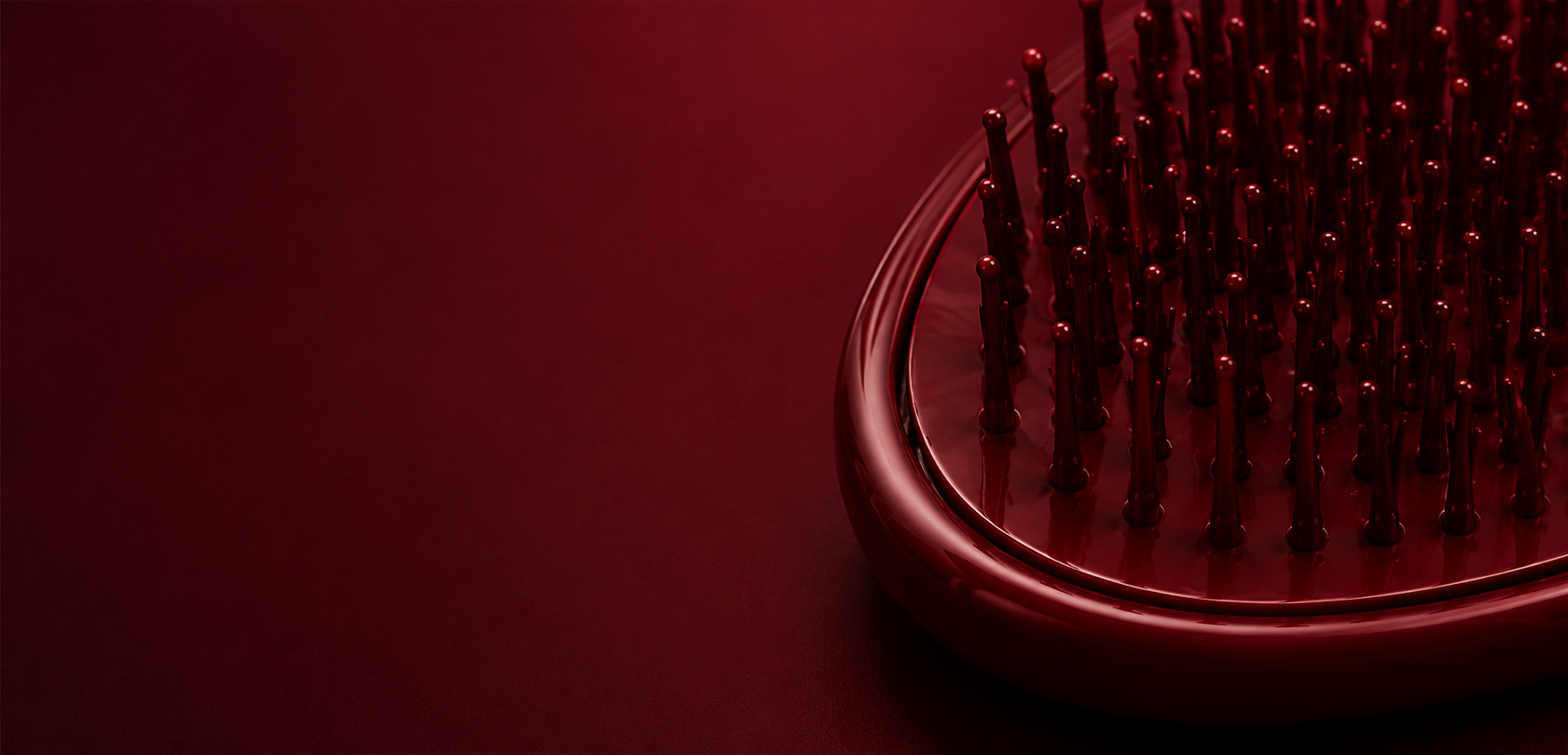 Red hairbrush on a dark red background